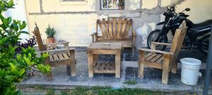 two wooden chairs and a table and a motorcycle at Tres Hermanos in Trinidad