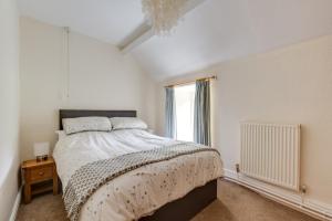 a white bedroom with a large bed and a window at 3 Bed in Tywyn oc-bow248 in Abergynolwyn
