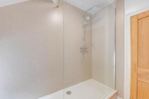 a shower with a glass door in a bathroom at 3 Bed in Tywyn oc-bow248 in Abergynolwyn +10 photos