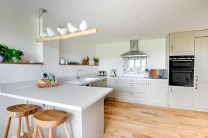 a kitchen with white cabinets and a kitchen island with stools at 2 Bed in Newton oc-swro in Sudbury