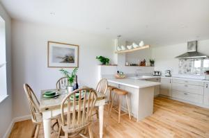 a kitchen with white cabinets and a table and chairs at 2 Bed in Newton oc-swro in Sudbury