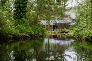 a house next to a river with trees at 4 Bed in Dinas Mawddwy oc-bow305 in Aber Cowarch