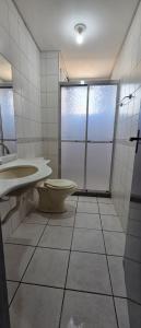 a bathroom with a toilet and a sink and a shower at Apto térreo aconchego e localização central in Santa Rosa