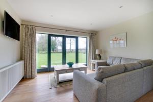 a living room with a couch and a large window at 2 Bed in Weybread oc-tclwey in Needham