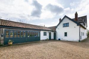 a white house with a black garage at 2 Bed in Weybread oc-tclwey in Needham