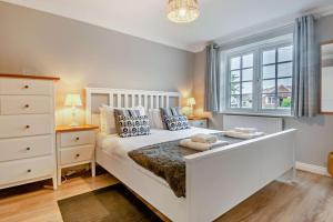 a bedroom with a large white bed and a window at 4 Bed in Southwold oc-hsumme in Reydon