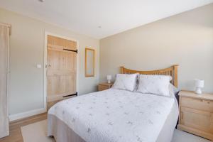 a bedroom with a white bed and a wooden door at 2 Bed in Weybread oc-tclwey in Needham