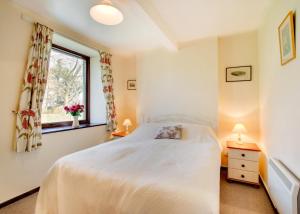 a bedroom with a white bed and a window at 2 Bed in Berwick-upon-Tweed oc-nb678 in Lowick