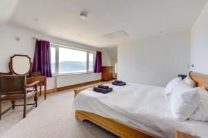 a bedroom with a bed and a desk and a mirror at 6 Bed in Barmouth oc-bow245 in Fairbourne