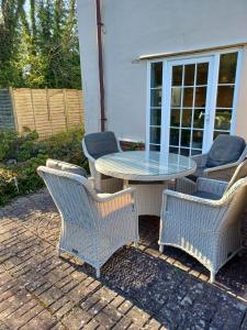 a table with four chairs and a table with a glass top at 2 Bed in Walberswick oc-5mart in Walberswick