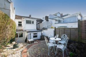 a patio with two tables and chairs in a backyard at 2 Bed in Mumbles oc-hh382 in The Mumbles