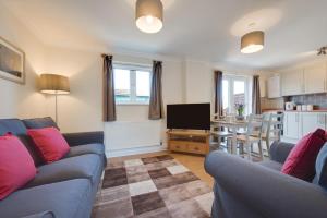 a living room with two blue couches and a kitchen at 3 Bed in Chedgrave oc-2252 in Chedgrave