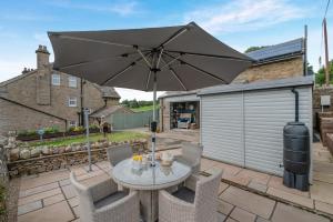 a table and chairs with an umbrella on a patio at 1 Bed in Askrigg oc-c33109 in Askrigg