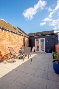 a patio with chairs and a table and a building at 3 Bed in Chedgrave oc-2252 in Chedgrave