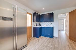 a kitchen with blue cabinets and a stainless steel refrigerator at 3 Bed in Llanfynydd oc-pw9215 in Llanfynydd