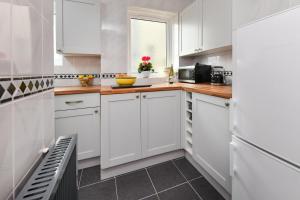 a kitchen with white cabinets and a window at 2 Bed in Nefyn oc-tynixs in Nefyn