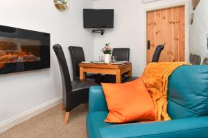 a living room with a blue couch and a table at 2 Bed in Nefyn oc-tynixs in Nefyn