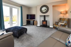 a living room with a couch and a fireplace at 3 Bed in Abersoch oc-16maes in Abersoch