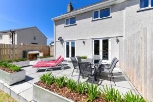 a patio with chairs and a table in front of a house at 3 Bed in Abersoch oc-16maes in Abersoch