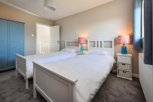 two beds in a bedroom with two lamps on tables at 3 Bed in Abersoch oc-16maes in Abersoch