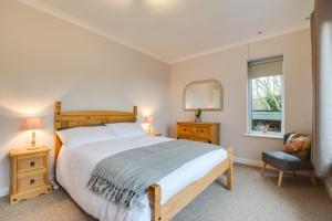 a bedroom with a bed and a chair and a window at 2 Bed in Port Eynon oc-hh2104 in Port-Eynon