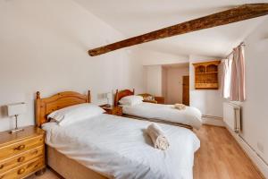 two beds in a bedroom with white walls and wooden floors at 4 Bed in Saxmundham oc-oth in Dunwich
