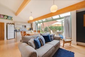 a living room with a couch with blue pillows at 2 Bed in Holt oc-2274 in Holt +10 photos