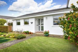 a white house with a lawn in front of it at 2 Bed in Abersoch oc-147cae in Abersoch