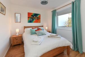a bedroom with a large white bed with a window at 2 Bed in Abersoch oc-147cae in Abersoch