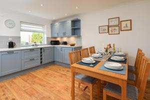a kitchen with a table and chairs in a kitchen at 2 Bed in Abersoch oc-147cae in Abersoch +9 photos