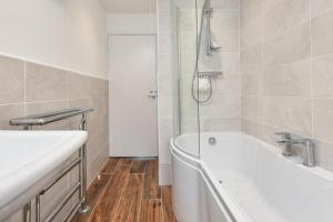 a bathroom with a bath tub and a sink at 2 Bed in Abersoch oc-147cae in Abersoch