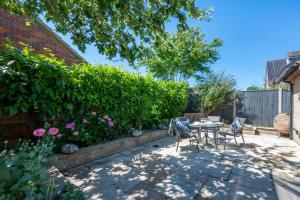 a patio with a table and chairs in a garden at 2 Bed in Holt oc-2274 in Holt