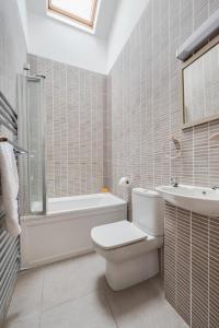 a bathroom with a toilet and a tub and a sink at 2 Bed in Holt oc-2274 in Holt