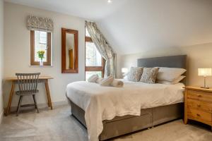 a bedroom with a large bed with a desk and a chair at 3 Bed in Aldeburgh oc-16afaw in Aldeburgh