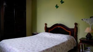 a bedroom with a bed with a white blanket and butterflies on the wall at SUÍTE em casa FRENTE AO MAR - Acesso à PRAIA, CHURRASQUEIRA, GARAGEM e WI-FI 80mbps - Ambiente Privativo - Itanhaém-SP in Itanhaém