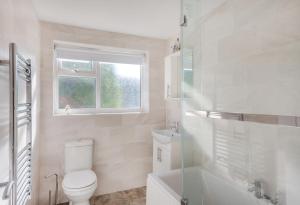 a white bathroom with a toilet and a window at 2 Bed in Abersoch oc-23caed in Abersoch +13 photos