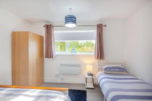 two beds in a small bedroom with a window at 2 Bed in Abersoch oc-23caed in Abersoch