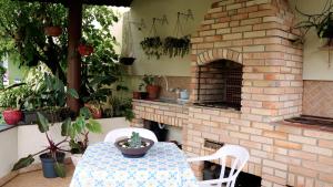 a patio with a table and a brick oven at SUÍTE em casa FRENTE AO MAR - Acesso à PRAIA, CHURRASQUEIRA, GARAGEM e WI-FI 80mbps - Ambiente Privativo - Itanhaém-SP in Itanhaém