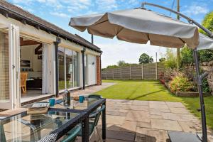 a patio with a table and an umbrella at 4 Bed in Slindon oc-t29883 in Eccleshall