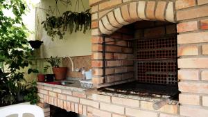an outdoor brick oven in a brick wall at SUÍTE em casa FRENTE AO MAR - Acesso à PRAIA, CHURRASQUEIRA, GARAGEM e WI-FI 80mbps - Ambiente Privativo - Itanhaém-SP in Itanhaém