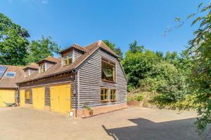 an old wooden house with a yellow garage at 2 Bed in Woodbridge oc-vav in Hollesley