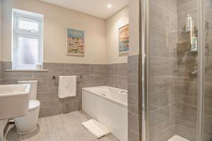 a bathroom with a tub and a toilet and a sink at 7 Bed in Aldeburgh oc-midba in Aldeburgh +33 photos