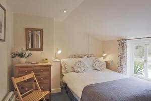 a bedroom with a bed and a dresser and a window at 3 Bed in Walberswick oc-aaferr in Walberswick