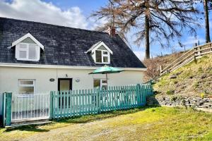 a white house with a fence and an umbrella at 3 Bed in Builth Wells oc-wal257 in Maesmynis