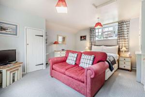 a bedroom with a red couch and a bed at 1 Bed in Yoxford oc-c27254 in Wickham Market