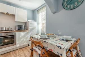 a kitchen with a table with two chairs and a clock at 3 Bed in Swanage oc-wy272 in Swanage +15 photos