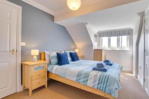 a bedroom with a bed with blue pillows at 3 Bed in Southwold oc-fie2 in Reydon