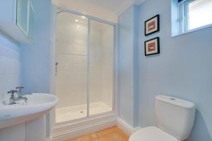a bathroom with a shower and a toilet and a sink at 3 Bed in Southwold oc-fie2 in Reydon +3 photos