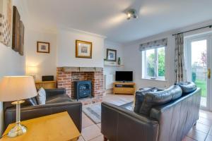 a living room with two leather couches and a fireplace at 3 Bed in Southwold oc-fie2 in Reydon