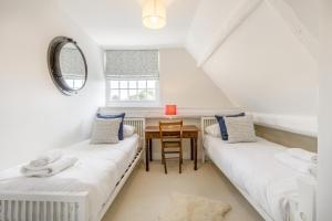 two beds in a room with a table and a window at 4 Bed in Cley oc-m33116 in Cley next the Sea
